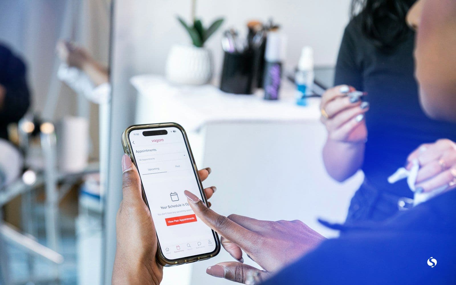 A phone showing a booking app in a salon