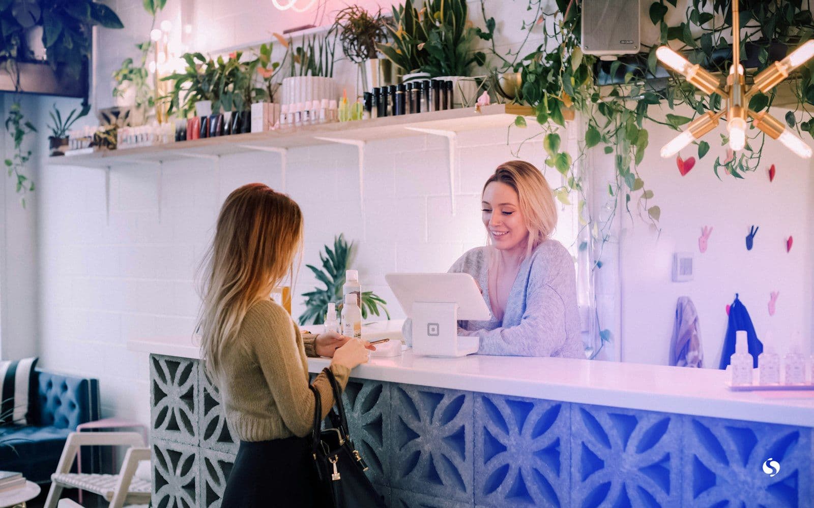 A customer paying at a shop counter with a smiling clerk