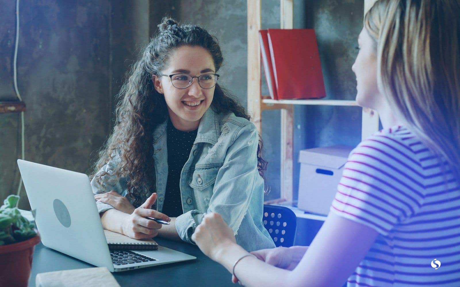Two women talking through a project at a laptop