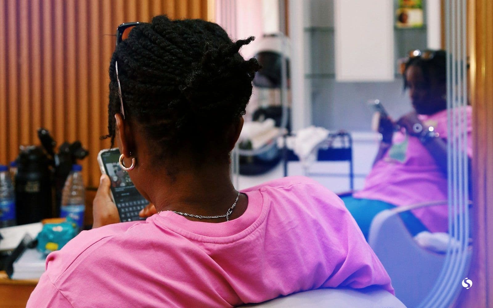 A customer checking her phone in a beauty salon